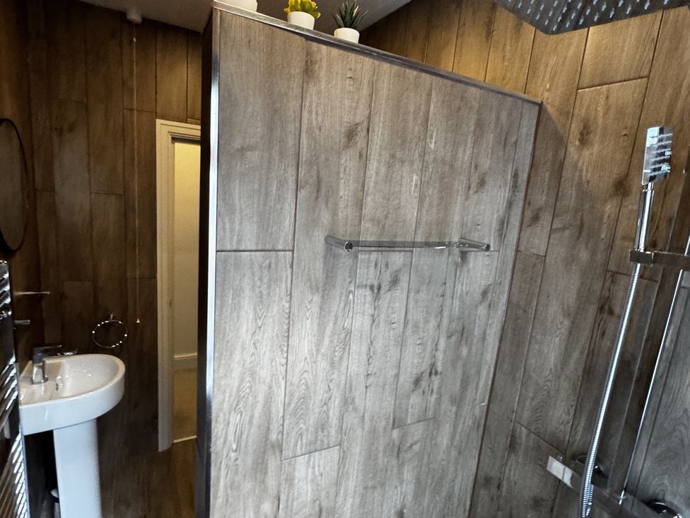 A bathroom with a shower and sink at Mostyn View in West Kirby