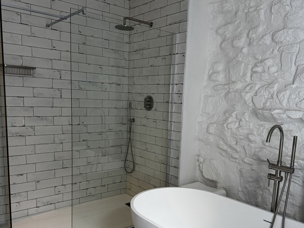 A bathroom with a glass shower and a bathtub at Mostyn View in West Kirby
