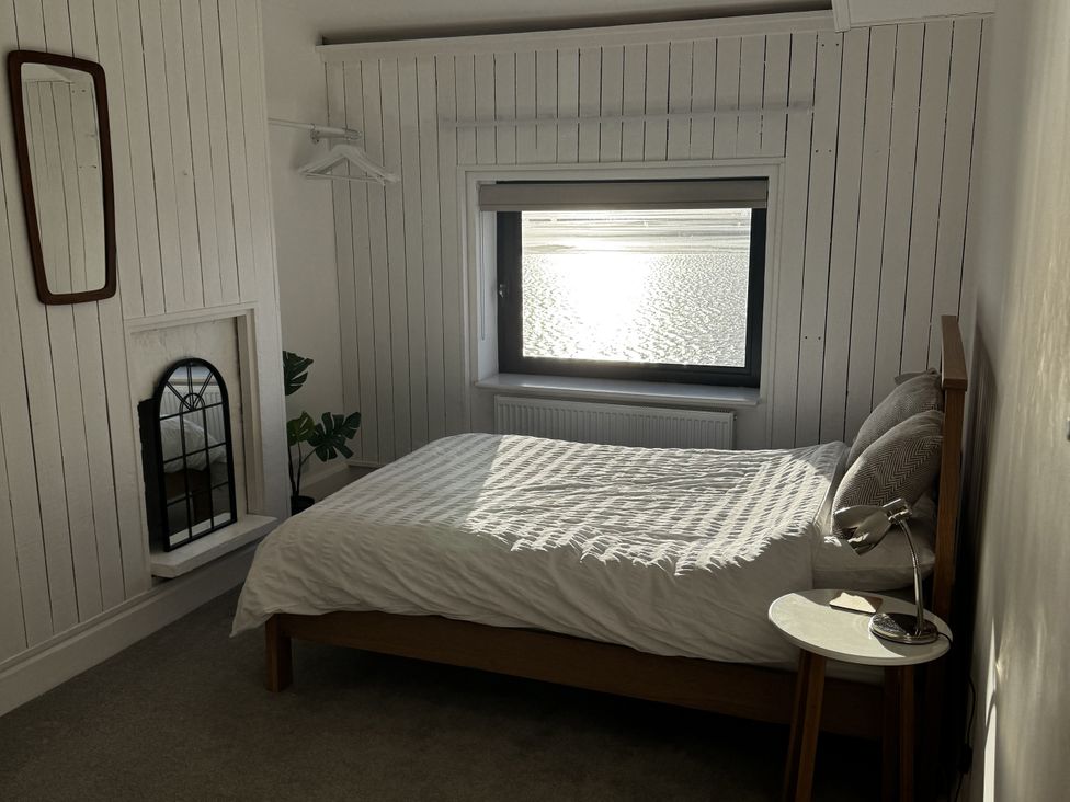 A bedroom with a bed and window at Mostyn View in West Kirby