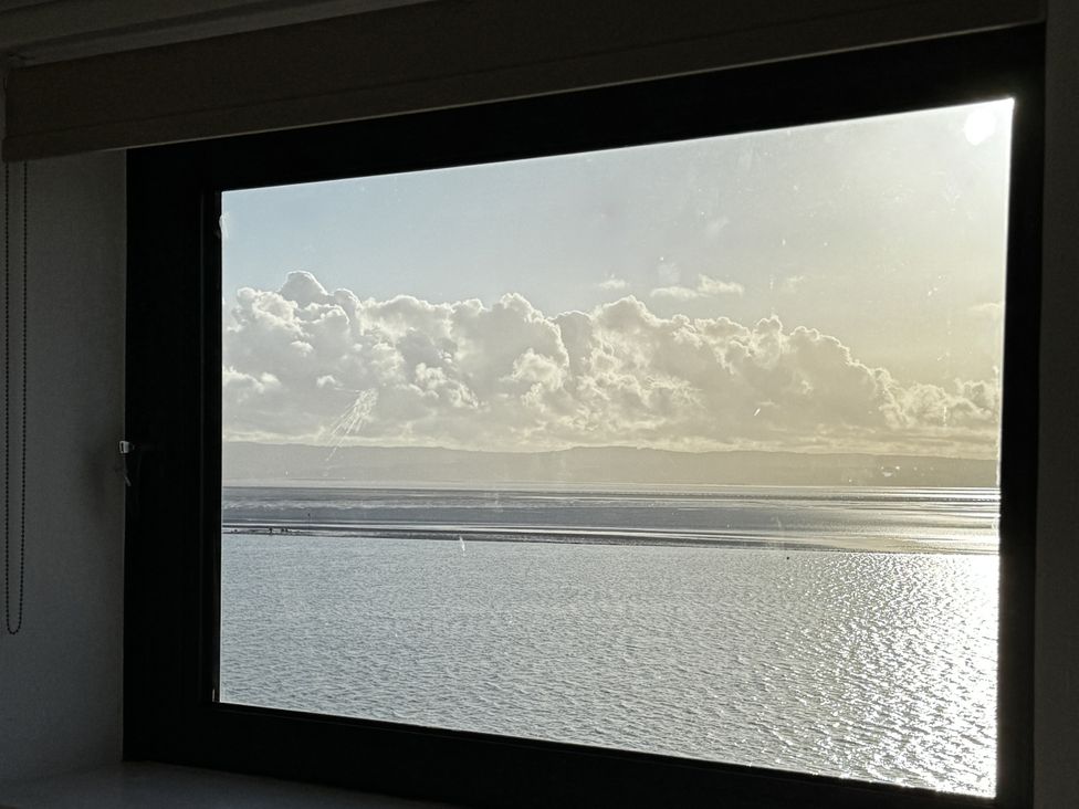 A view of clouds over the ocean through a window at Mostyn View in West Kirby