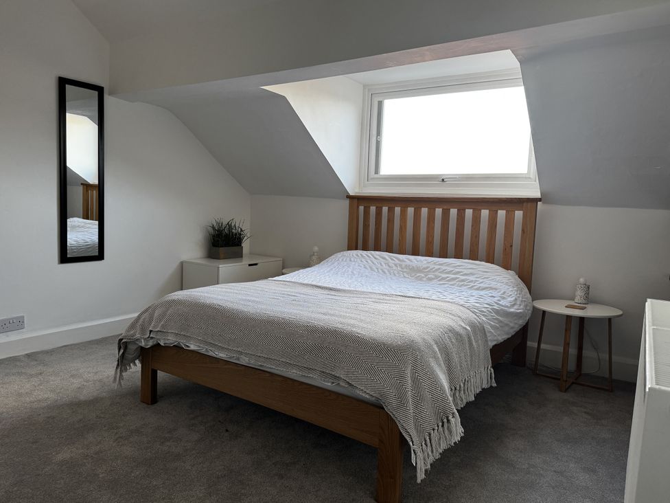 A bedroom with a bed and mirror at Mostyn View West Kirby