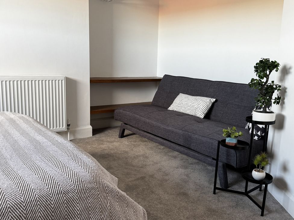 A living room with a sofa and plants at Mostyn View in West Kirby
