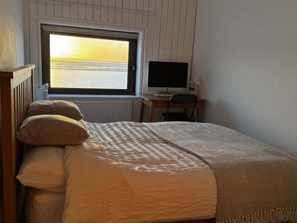 A bedroom with a bed and desk beside a window at Mostyn View in West Kirby