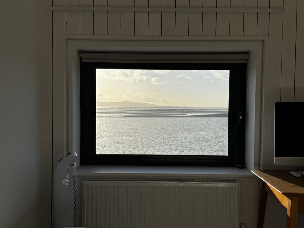 A view of water and mountains from a window at Mostyn View in West Kirby