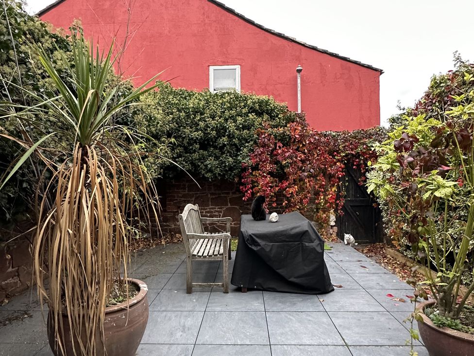 A garden with a table and chairs at Mostyn View in West Kirby