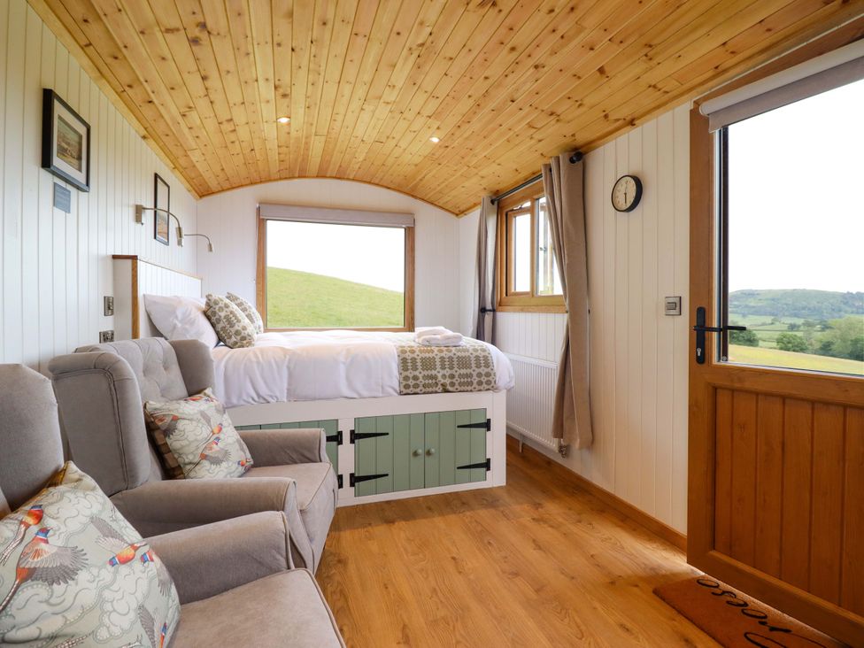 A sleeping area with a bed and sofa at Defaid Cymreig in Oswestry