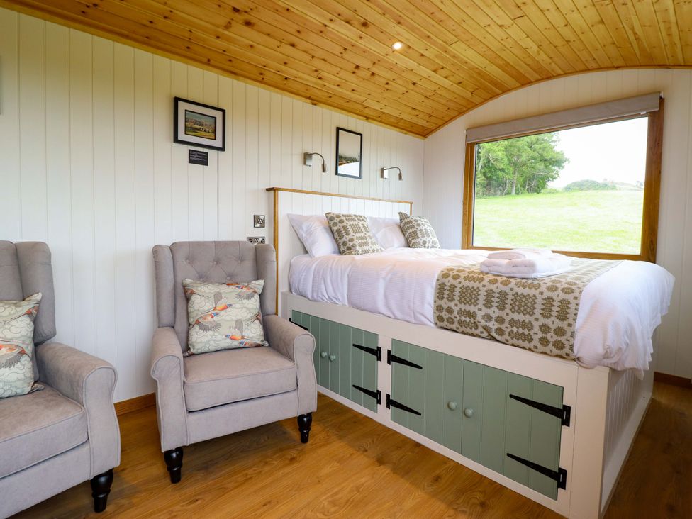 A bedroom with a bed and armchairs at Defaid Cymreig Oswestry
