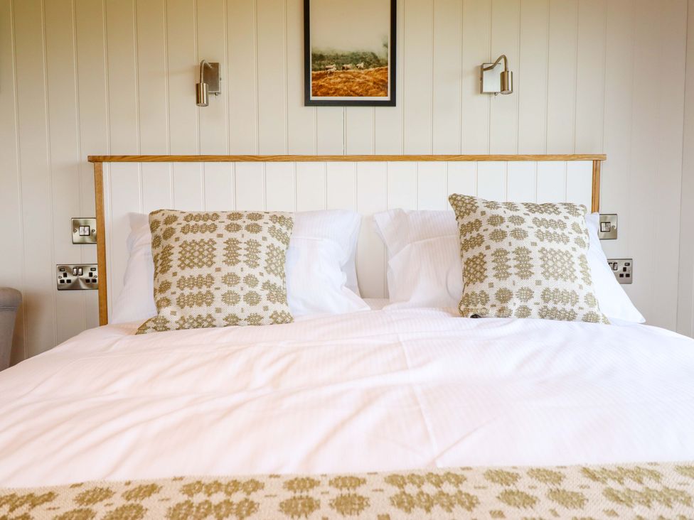 A bedroom with a bed and pillows at Defaid Cymreig in Oswestry