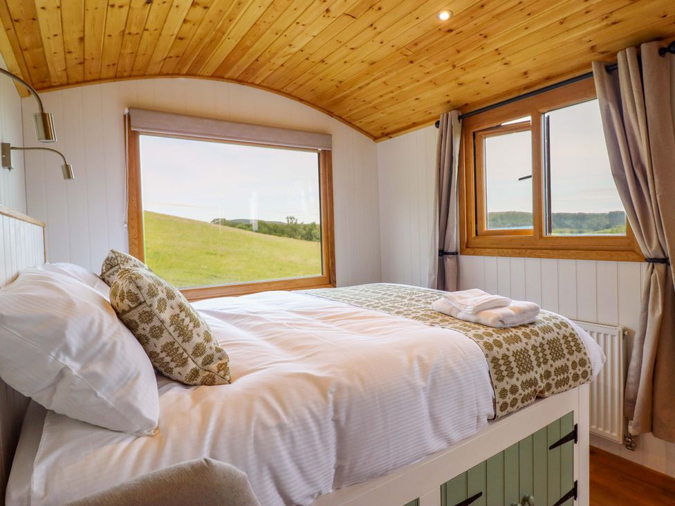 A bedroom with a bed and windows at Defaid Cymreig in Oswestry