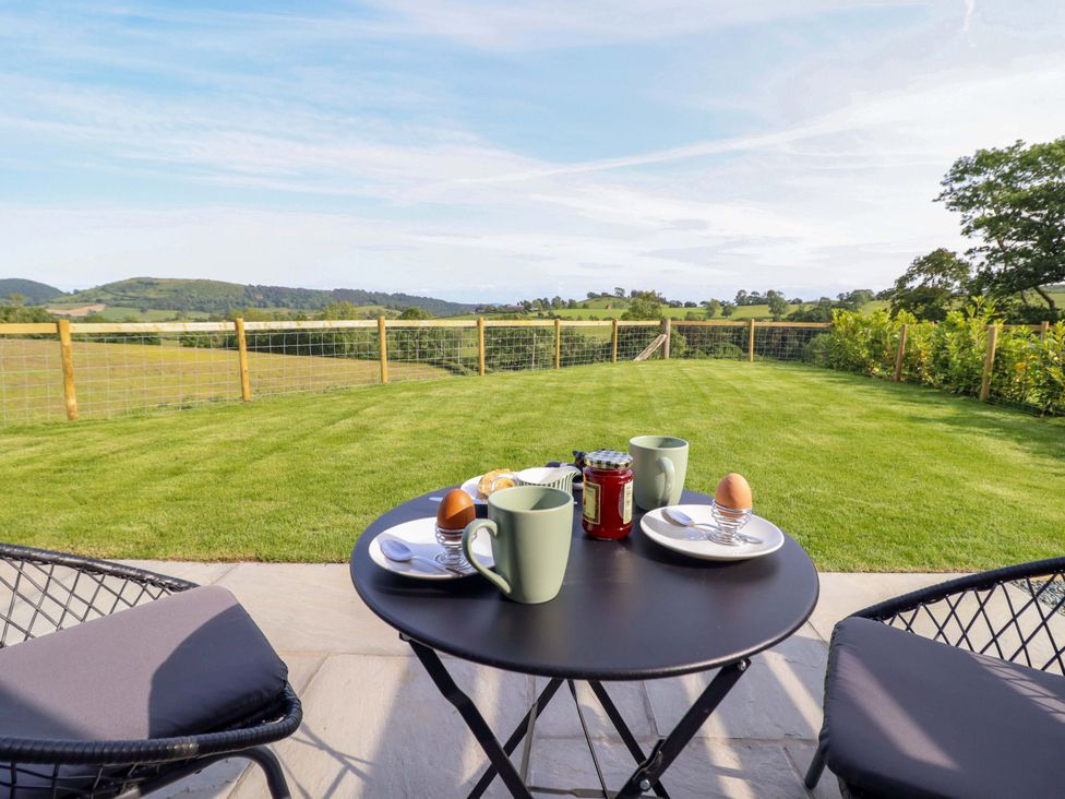 A table with cups and food items on a patio at Defaid Cymreig, Oswestry