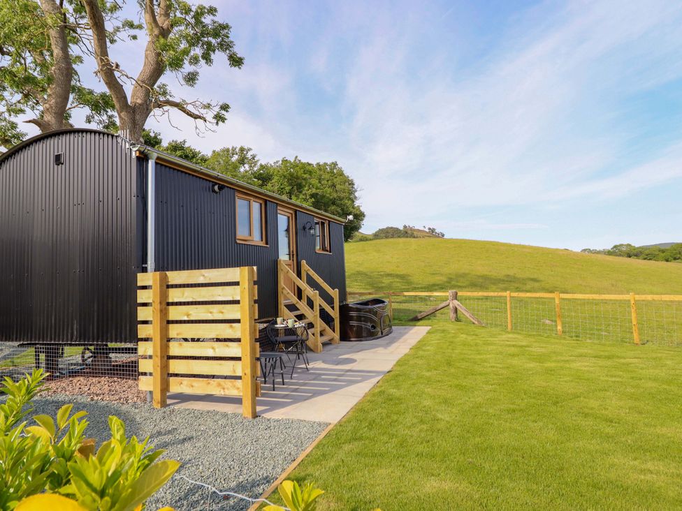 An outdoor space with a building, fence, and hot tub at Defaid Cymreig Oswestry