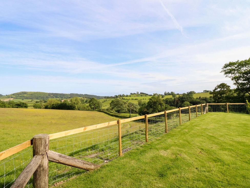 A view of hills and a fence in a grassy area at Defaid Cymreig in Oswestry