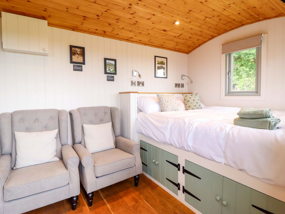 A bedroom with a bed and armchairs at Cheviot in Oswestry