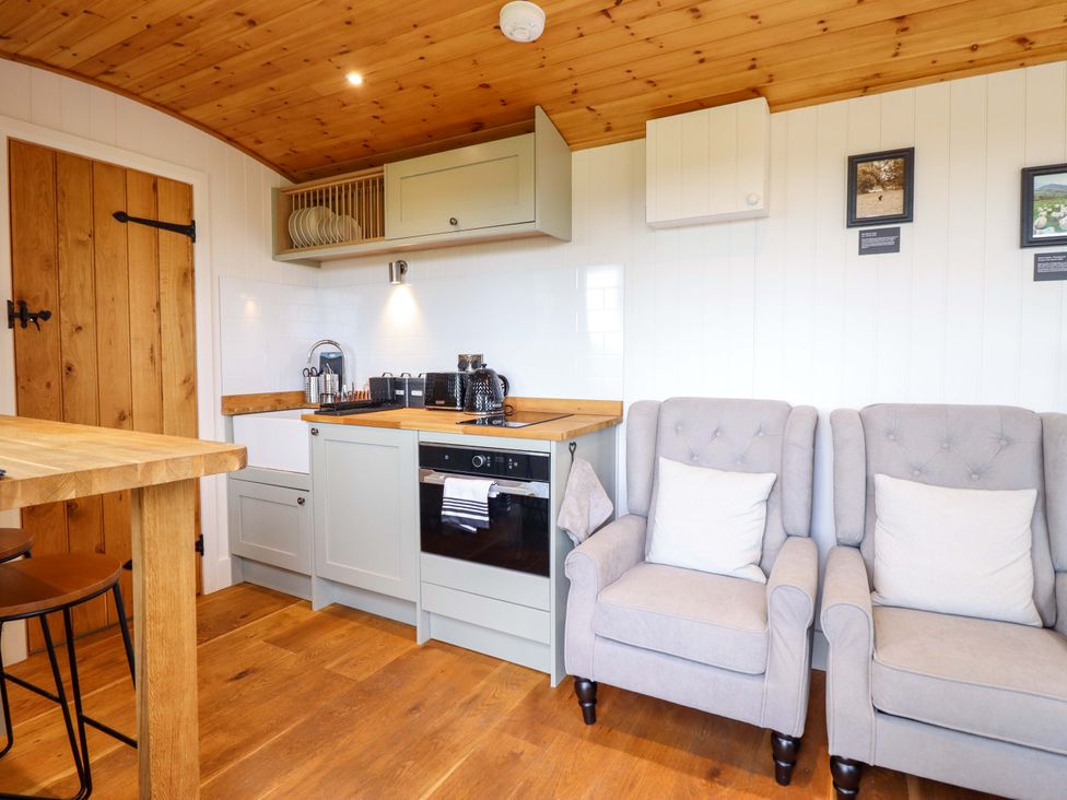 A kitchen with cabinets and seating area at Cheviot in Oswestry