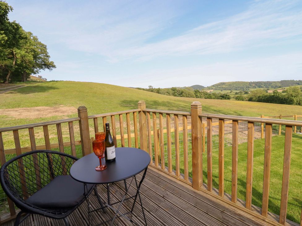 A table and chairs with a wine bottle and glasses on an outdoor terrace at Cheviot in Oswestry