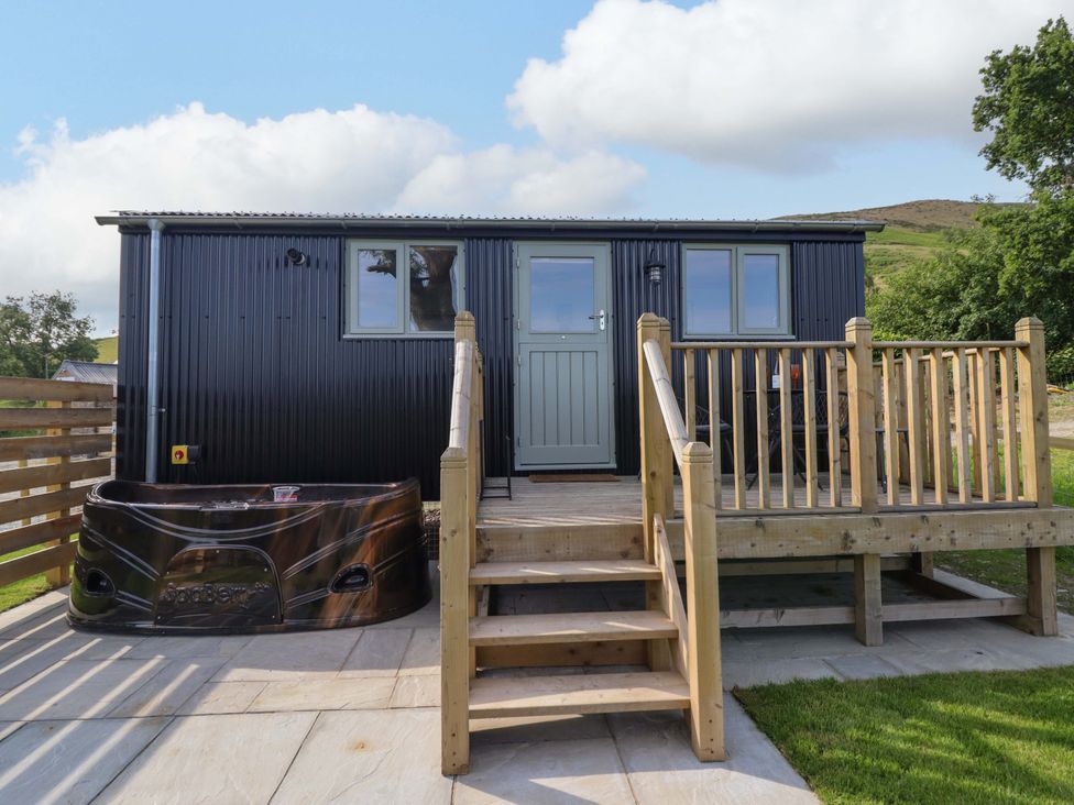 A cabin with a hot tub and stairs at Cheviot in Oswestry