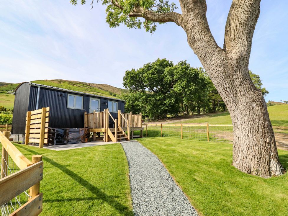 A house with a deck and a tree in the garden at Cheviot in Oswestry