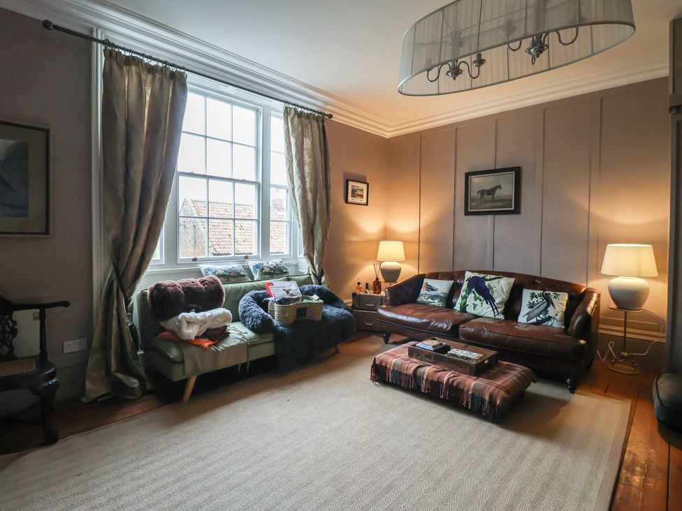 A living room with multiple sofas and a coffee table at Elstronwick Hall Apartment