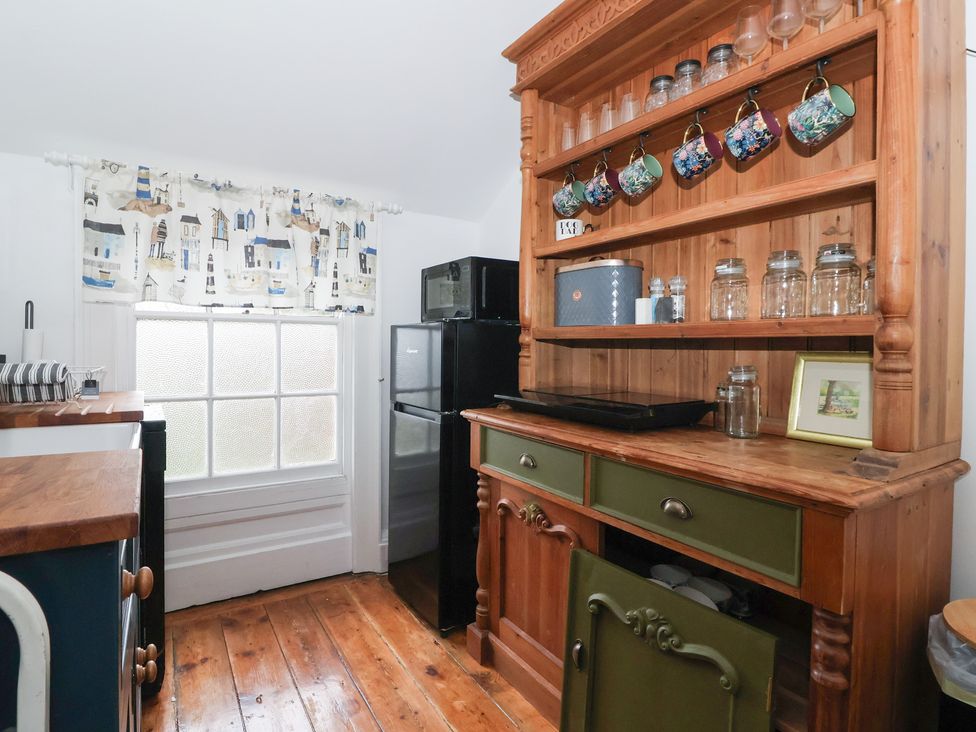 A kitchen with cabinets and refrigerator at Elstronwick Hall Apartment 