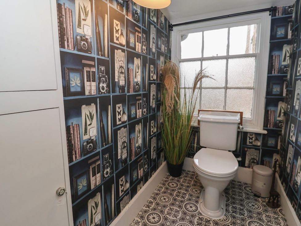 A bathroom with a toilet and a window at Elstronwick Hall Apartment