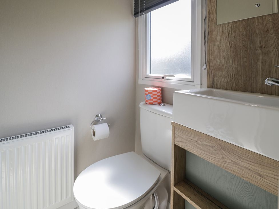 A bathroom with a toilet and sink at Puffin Way Holiday Caravan