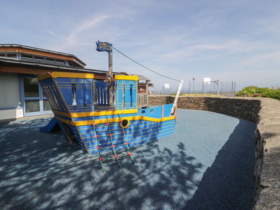 A playground with a pirate ship climbing structure at Puffin Way Holiday Caravan