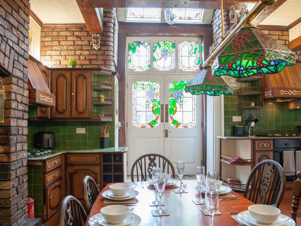 A kitchen with a dining area and stained glass door at 4 Kingscliffe Street in Manchester