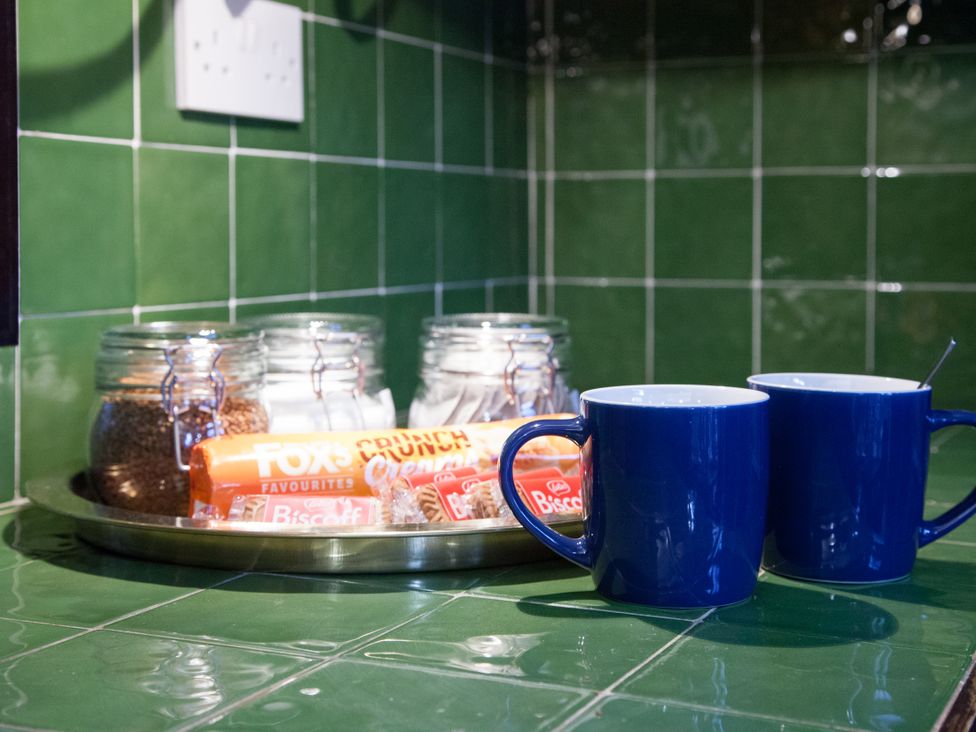 A kitchen counter with mugs, cookies, and jars at 4 Kingscliffe Street in Manchester