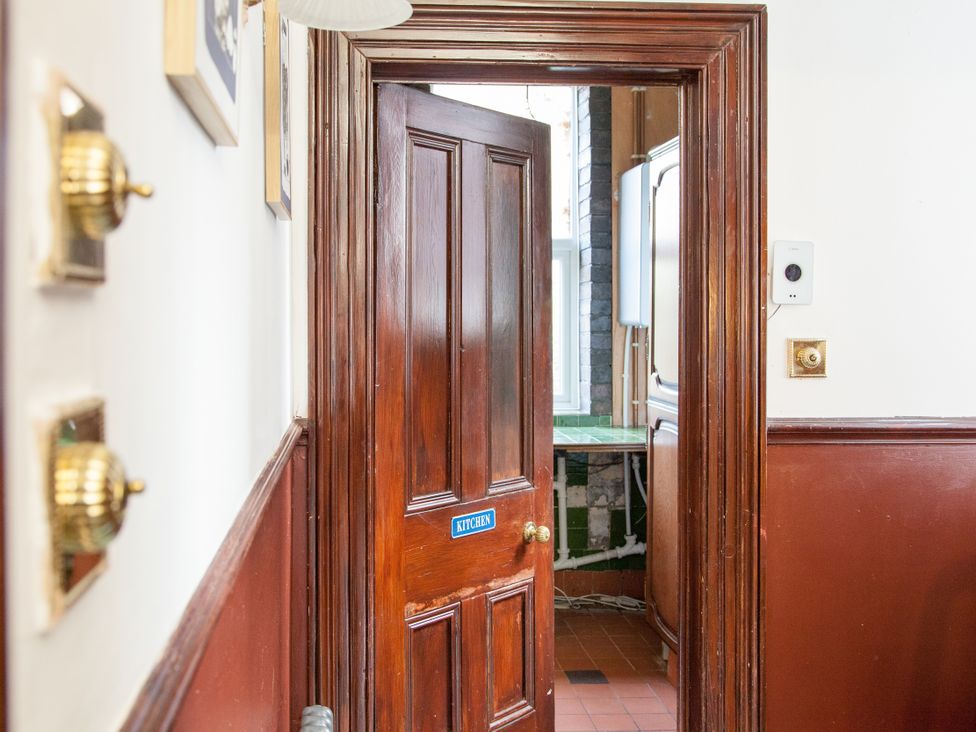 A hallway with a door labeled kitchen at 4 Kingscliffe Street Manchester