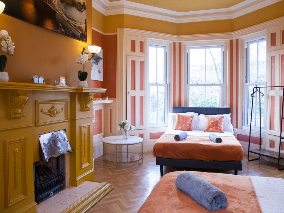 A bedroom with two beds and a fireplace at 4 Kingscliffe Street in Manchester