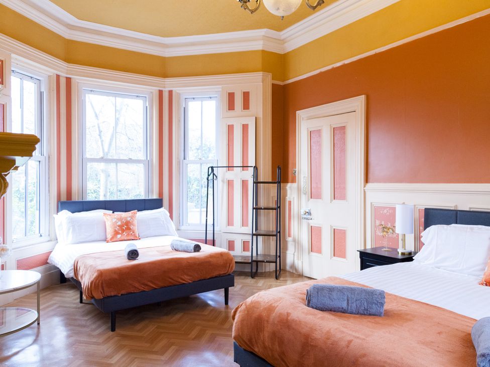 A bedroom with two beds and a shelf at 4 Kingscliffe Street in Manchester