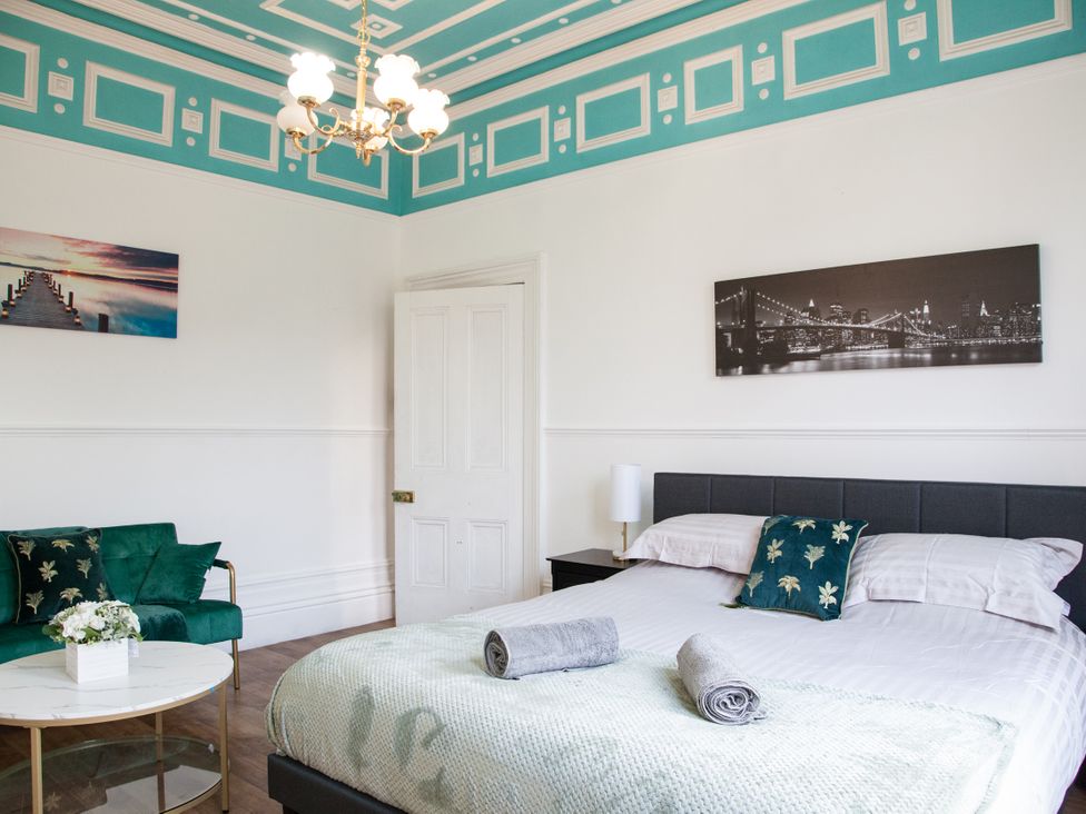 A bedroom with bed and sofa at 4 Kingscliffe Street in Manchester