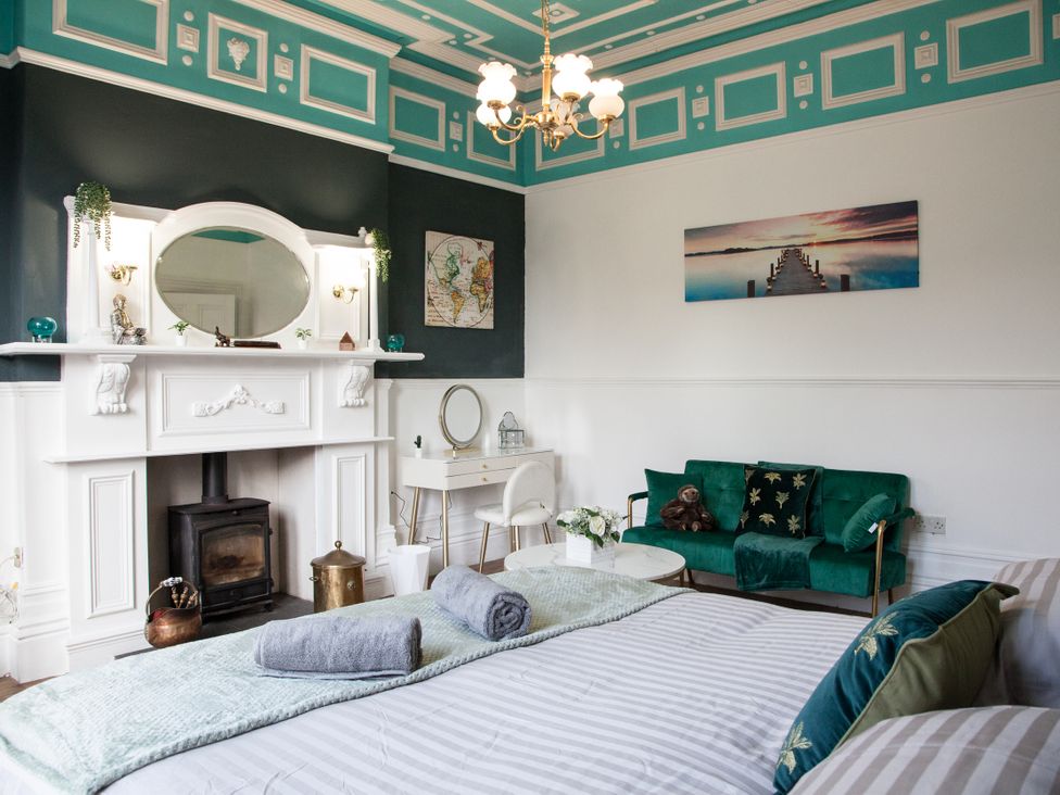 A bedroom with a bed and a sofa at 4 Kingscliffe Street in Manchester