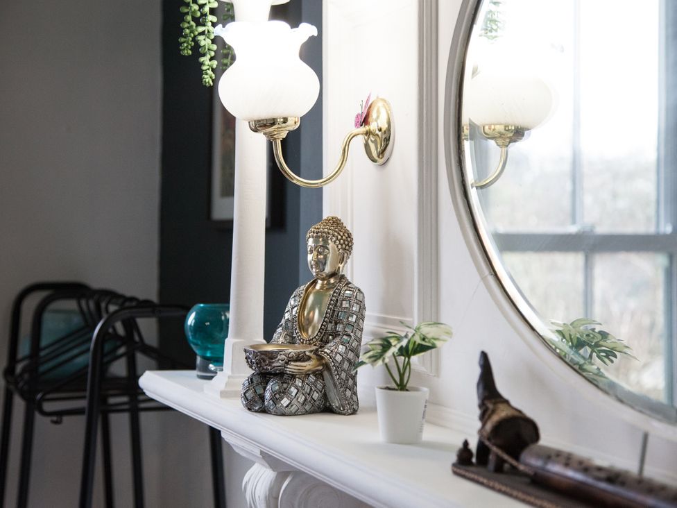 A living room with a buddha statue and lamp at 4 Kingscliffe Street Manchester