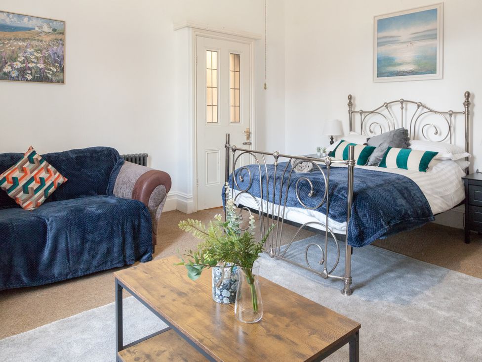 A bedroom with a bed and a sofa at 4 Kingscliffe Street in Manchester