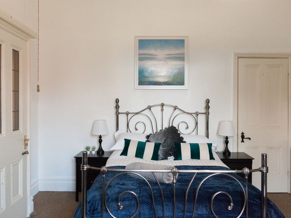 A bedroom with a bed and bedside tables at 4 Kingscliffe Street in Manchester