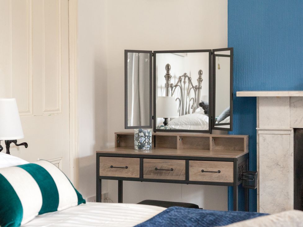 A bedroom with a vanity table and mirror at 4 Kingscliffe Street in Manchester