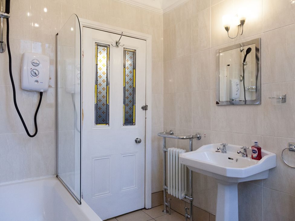 A bathroom with a bathtub and wash basin at 4 Kingscliffe Street Manchester