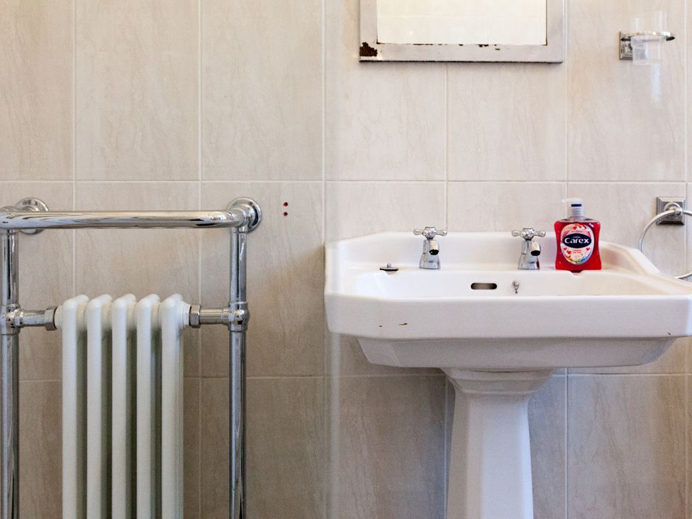 A bathroom with a sink and towel radiator at 4 Kingscliffe Street in Manchester