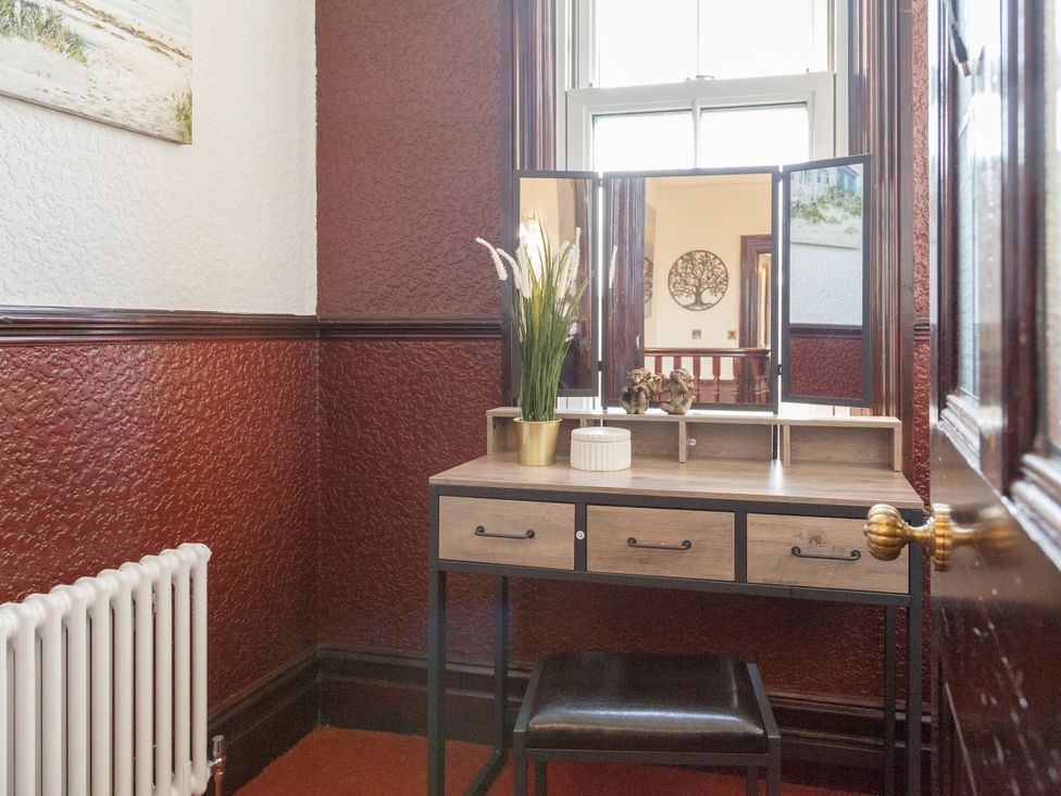 A vanity table with a mirror and chair at 4 Kingscliffe Street Manchester