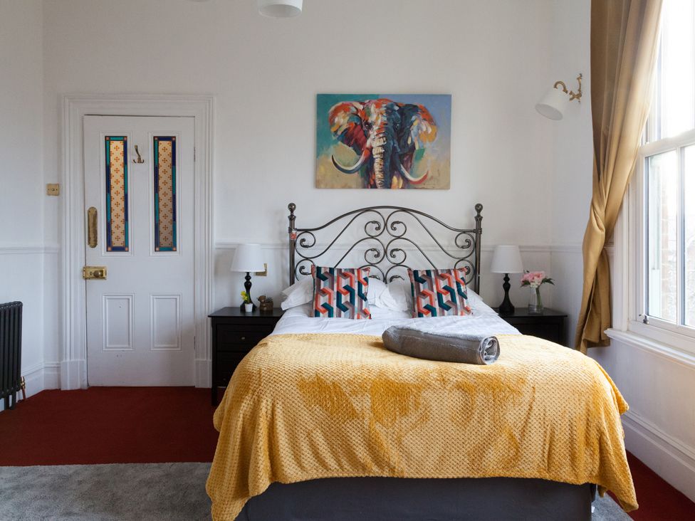 A bedroom with a bed and painting at 4 Kingscliffe Street Manchester