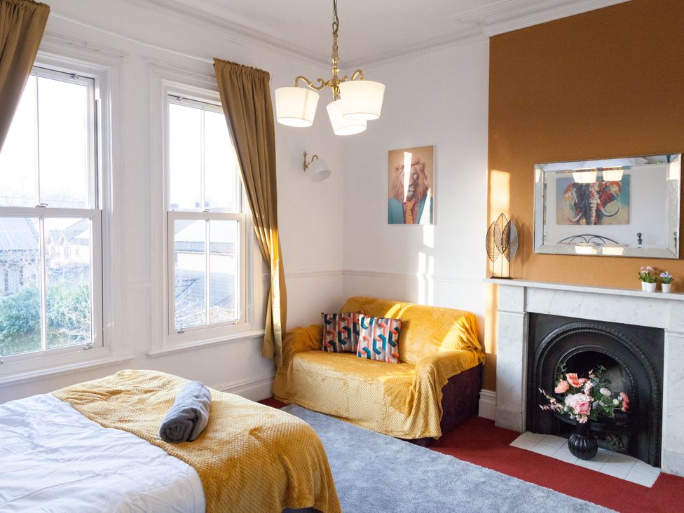 A bedroom with a bed and a sofa at 4 Kingscliffe Street in Manchester