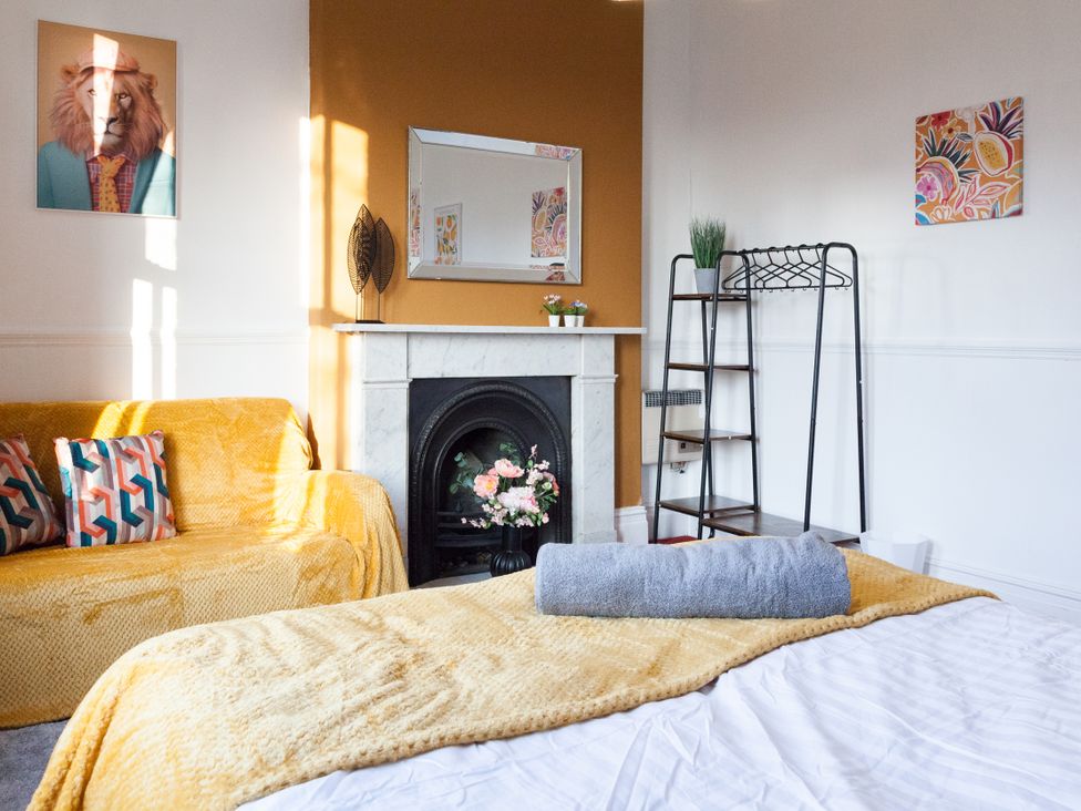 A living room with a sofa and fireplace at 4 Kingscliffe Street in Manchester