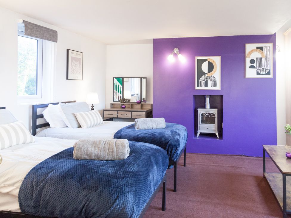 A bedroom with two beds and a mirror at 4 Kingscliffe Street in Manchester