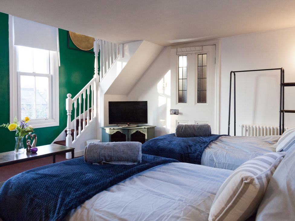 A guest room with two beds and a television at 4 Kingscliffe Street in Manchester