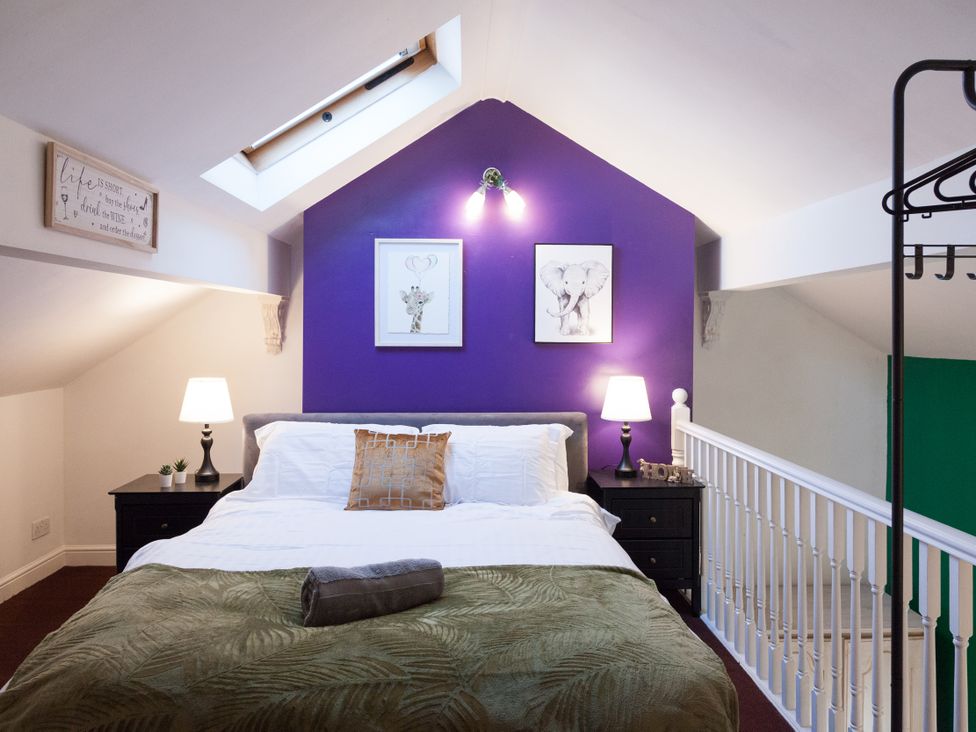 A bedroom with a bed and nightstands at 4 Kingscliffe Street in Manchester