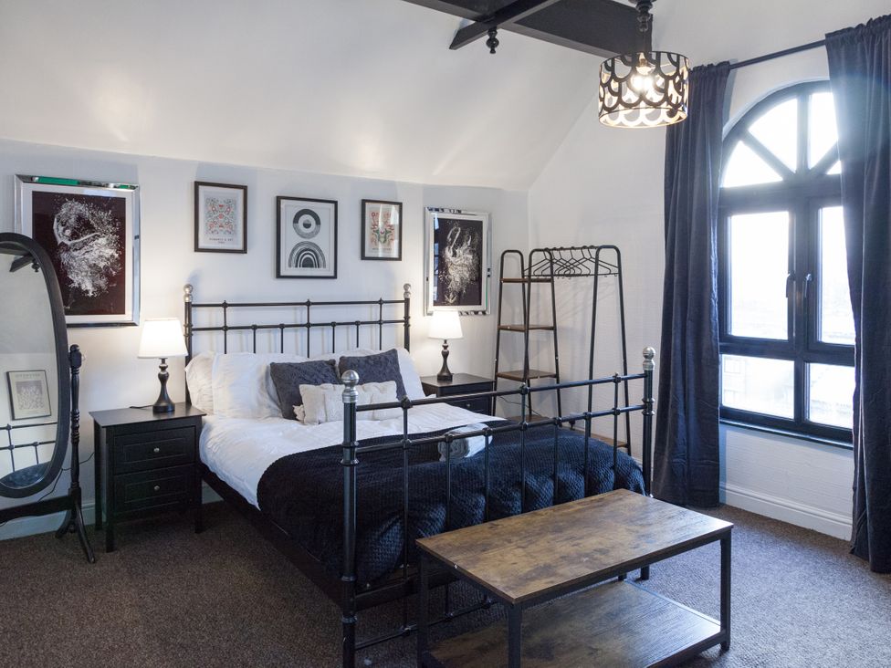 A bedroom with a bed and side tables at 4 Kingscliffe Street in Manchester