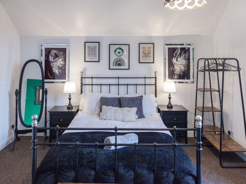 A bedroom with a bed and art on the walls at 4 Kingscliffe Street Manchester
