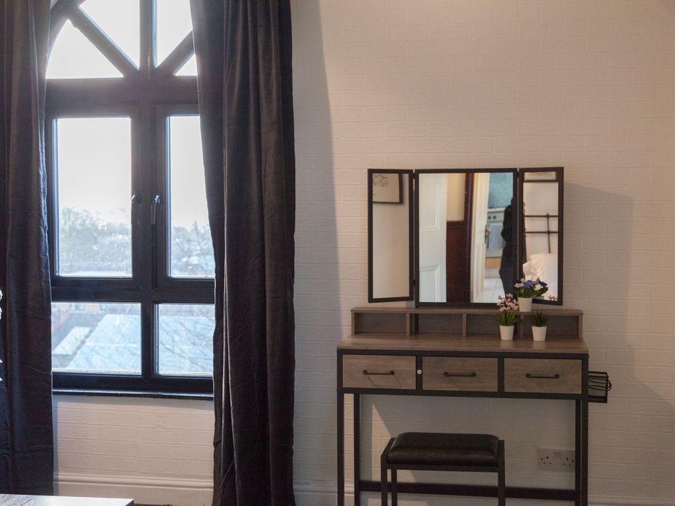 A bedroom with a vanity table and mirror at 4 Kingscliffe Street Manchester