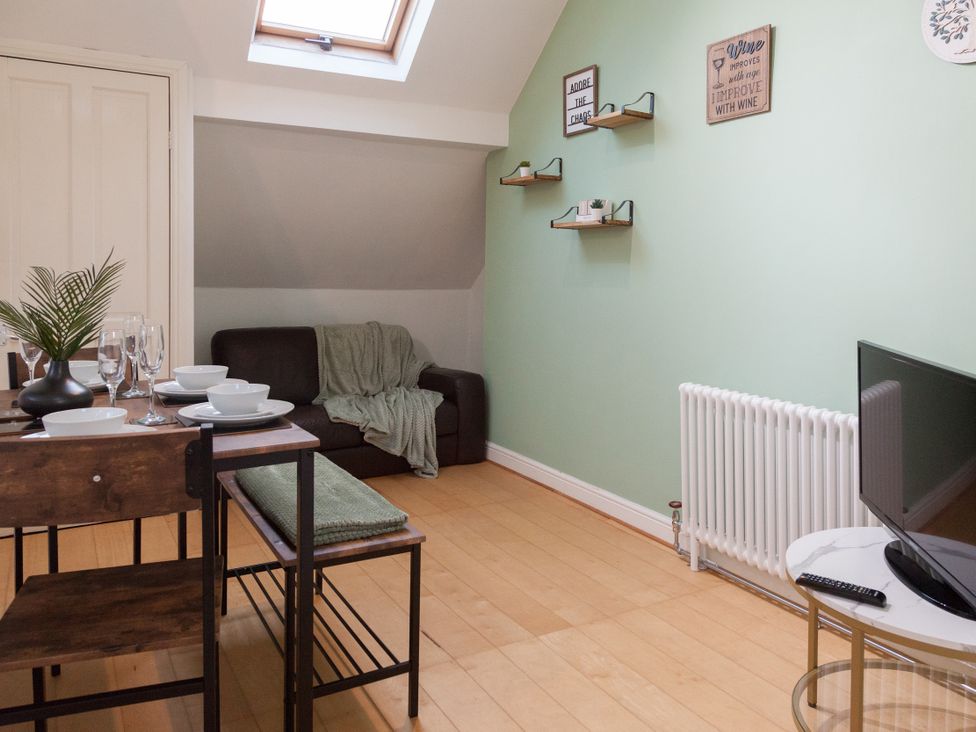 A living room with a sofa and dining table at 4 Kingscliffe Street in Manchester